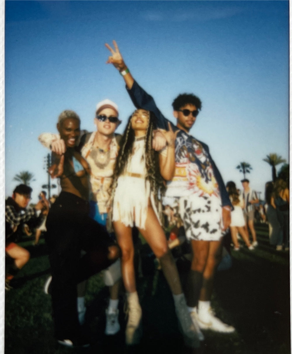 Polaroid of four young people at a festival.