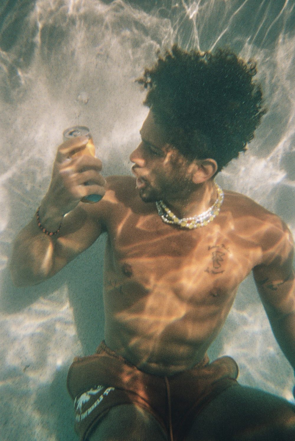 Jovan Clark sits underwater with a can of Cool Cat.