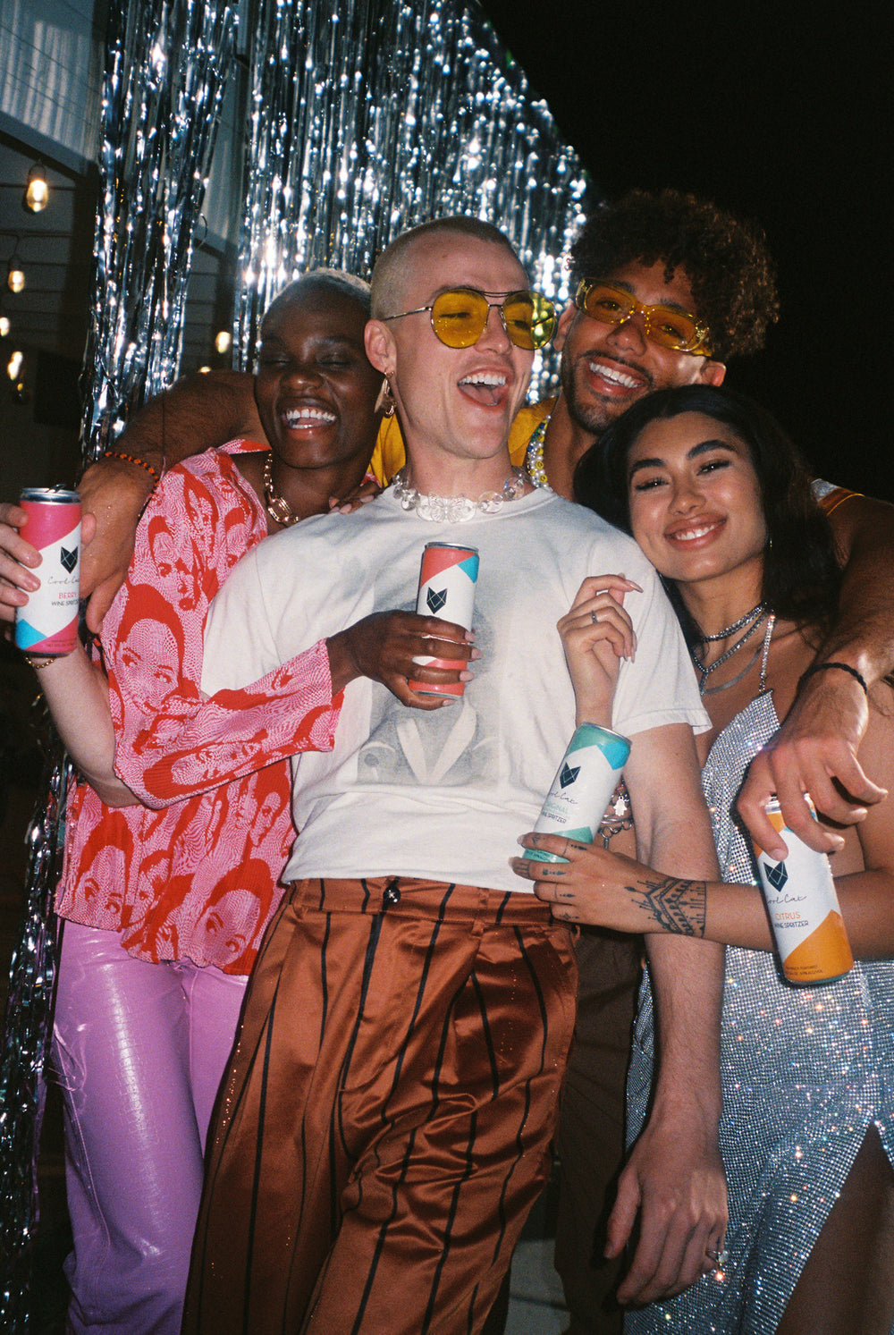 Young partygoers holding different flavors of Cool Cat canned wine spritzers.