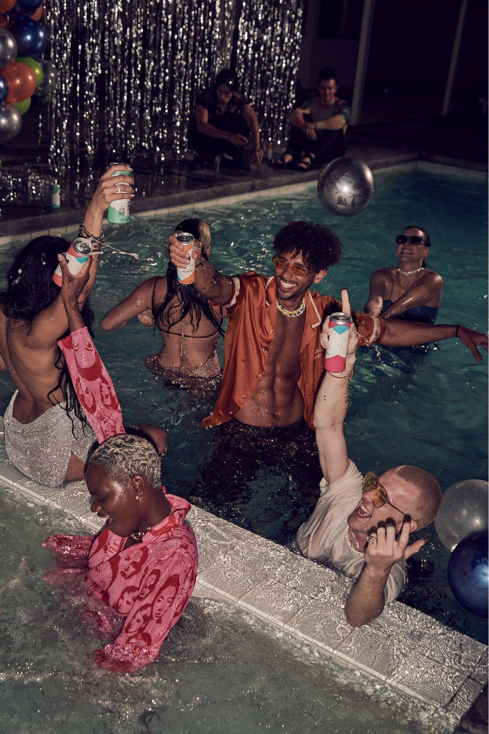 Young adults at a pool party holding Cool Cat Wine Spritzers.