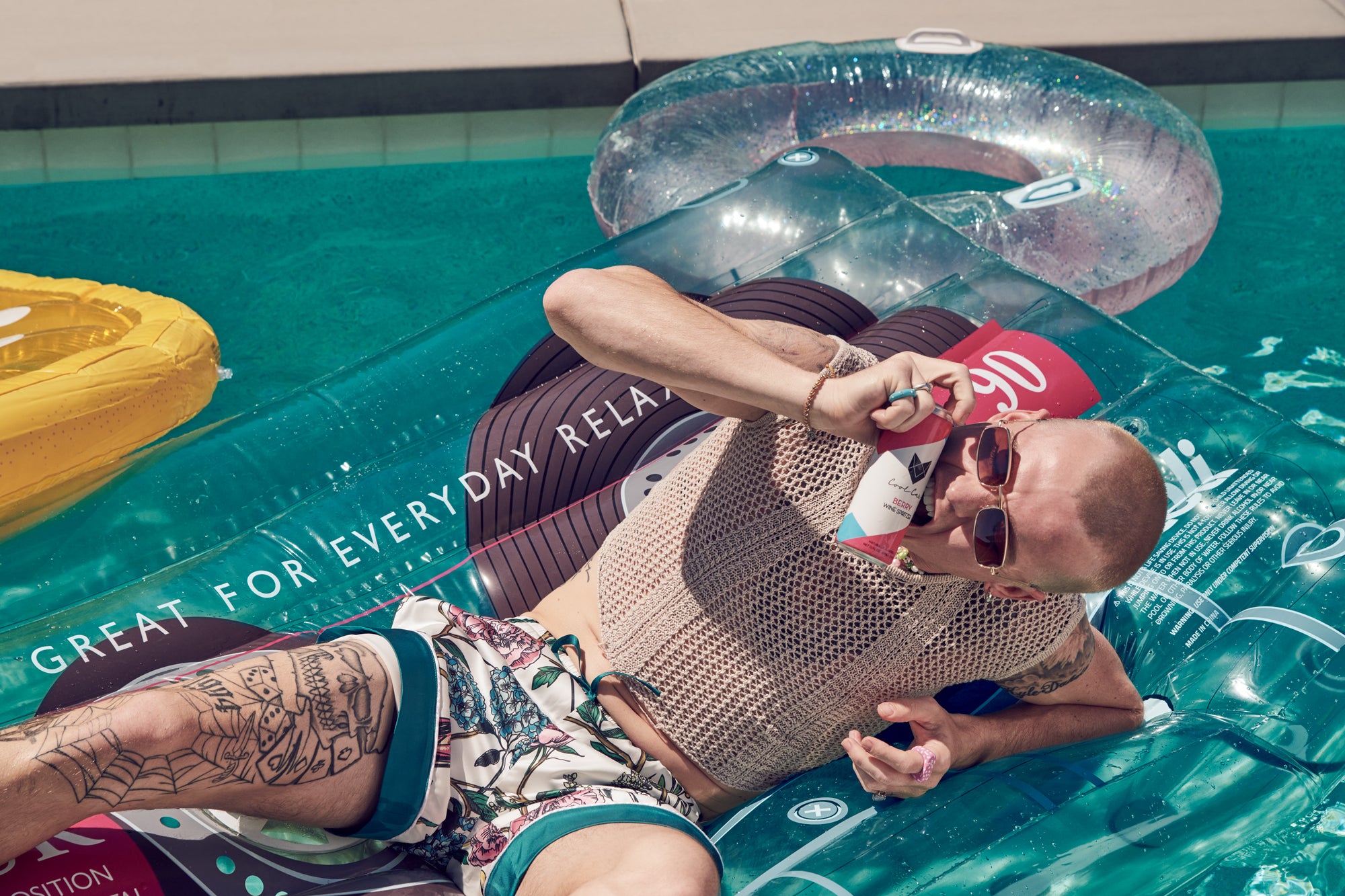 Dakota Griffin holds a Berry Cool Cat Wine Spritzer can to his face in the pool.