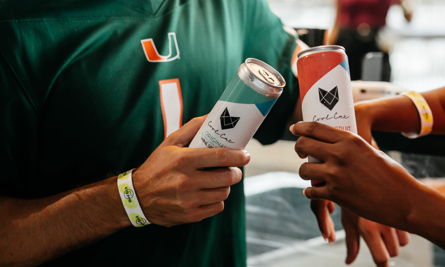 Two University of Miami Hurricanes fans cheers their cans of Cool Cat Wine Spritzers.