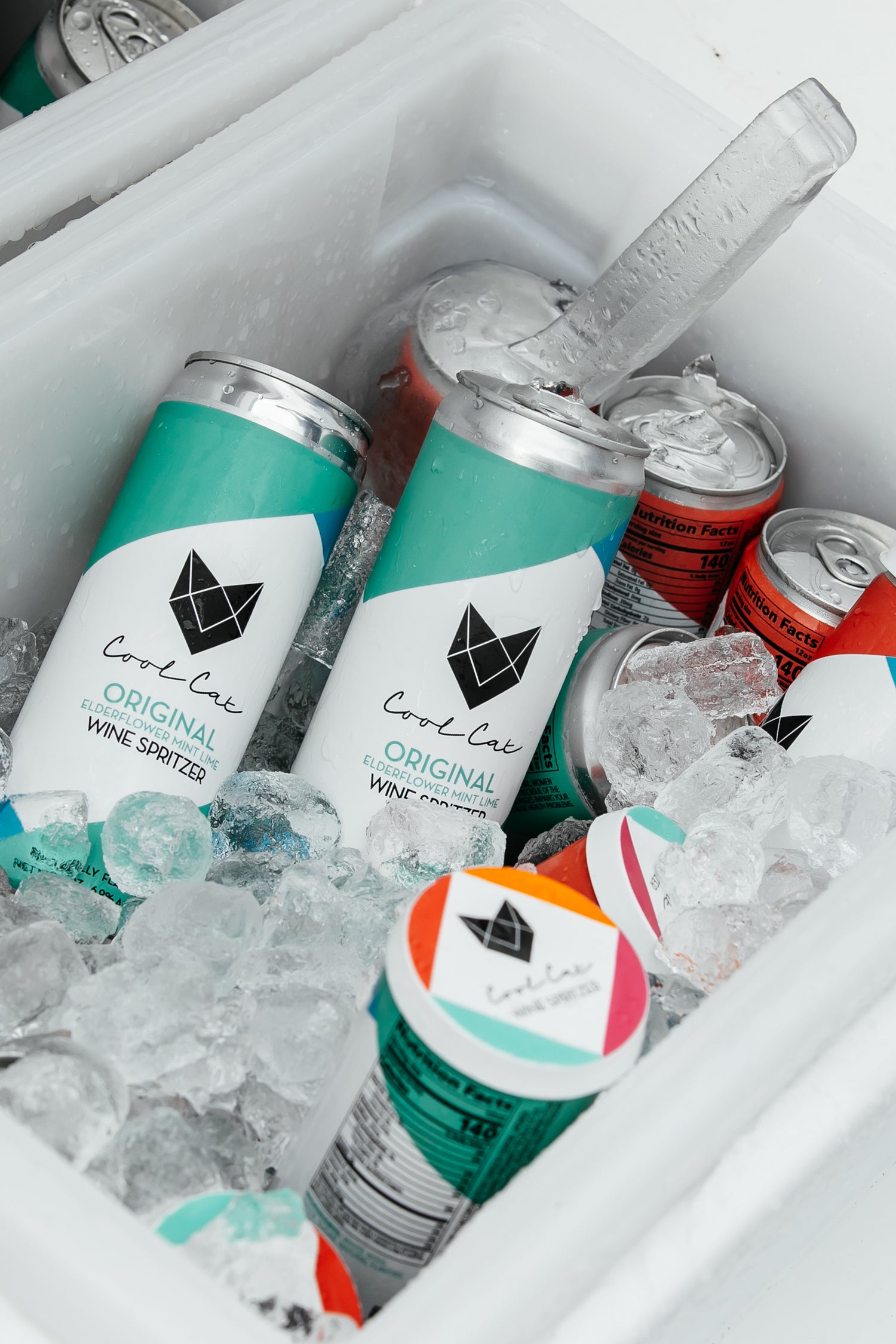 Cans of Cool Cat Sparkling Cocktail in a cooler with ice.