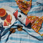 A can of Cool Cat next to grapefruits on a towel by the pool.