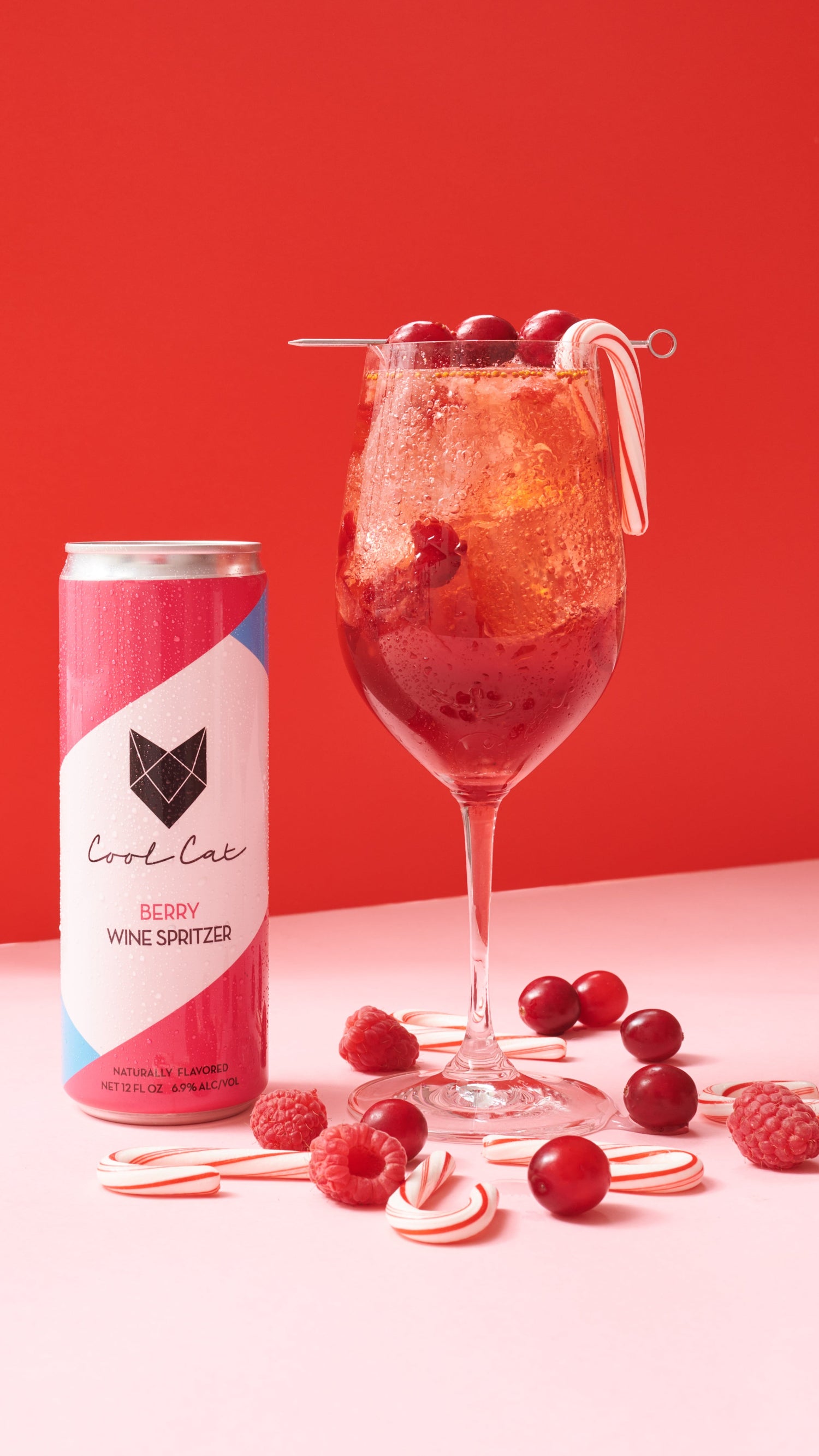 The Merry Berry holiday cocktail next to a can of Cool Cat Berry Wine Spritzer.